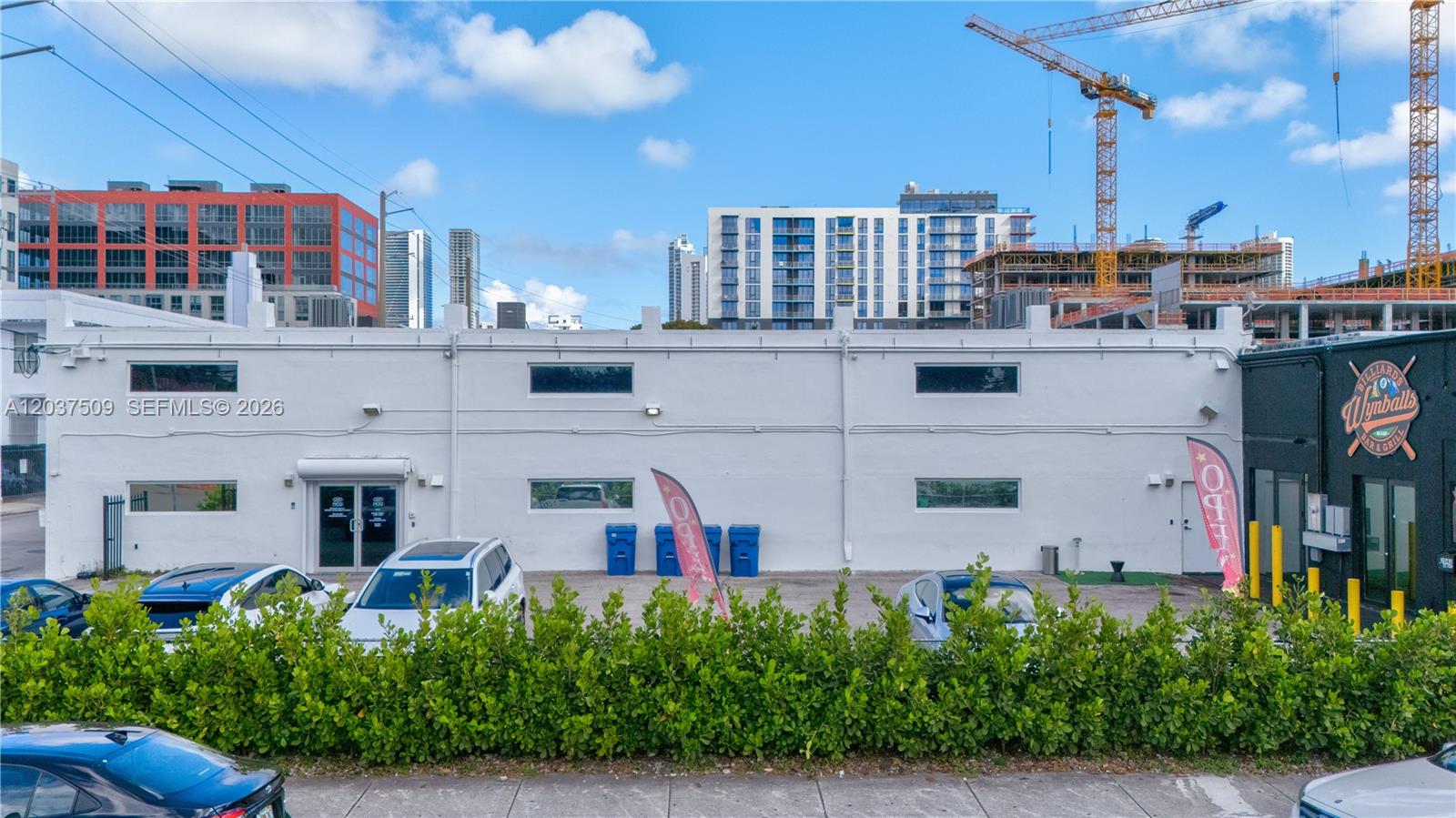 A white commercial building with a parking lot and a black-painted business entrance — 2045 NW 1st Ave, Miami FL 33127, MIAMI, FL