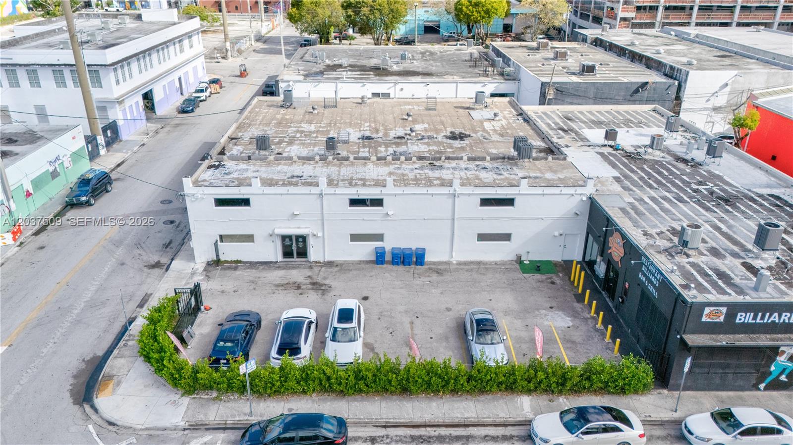 An aerial view shows a white commercial building with a parking lot and surrounding streets — 2045 NW 1st Ave, Miami FL 33127, MIAMI, FL