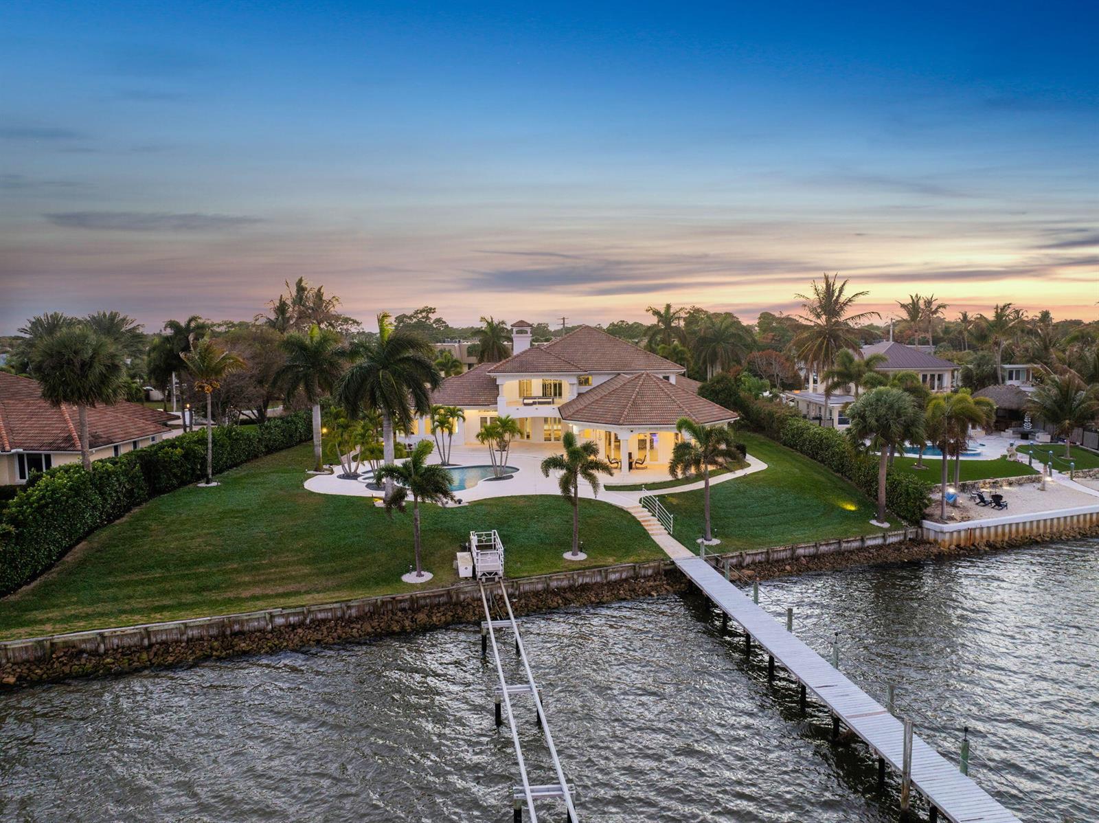 An aerial view of a waterfront house with a pool, palm trees, and a dock — 1735 SE St Lucie Boulevard, Stuart FL 34996, STUART, FL