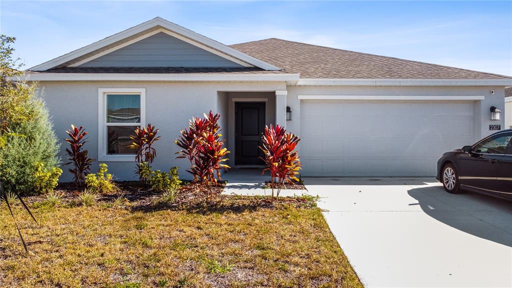 A single-story house with a light gray exterior, a two-car garage, and a front walkway — 2307 SCARLET AVENUE, WINTER HAVEN, FL