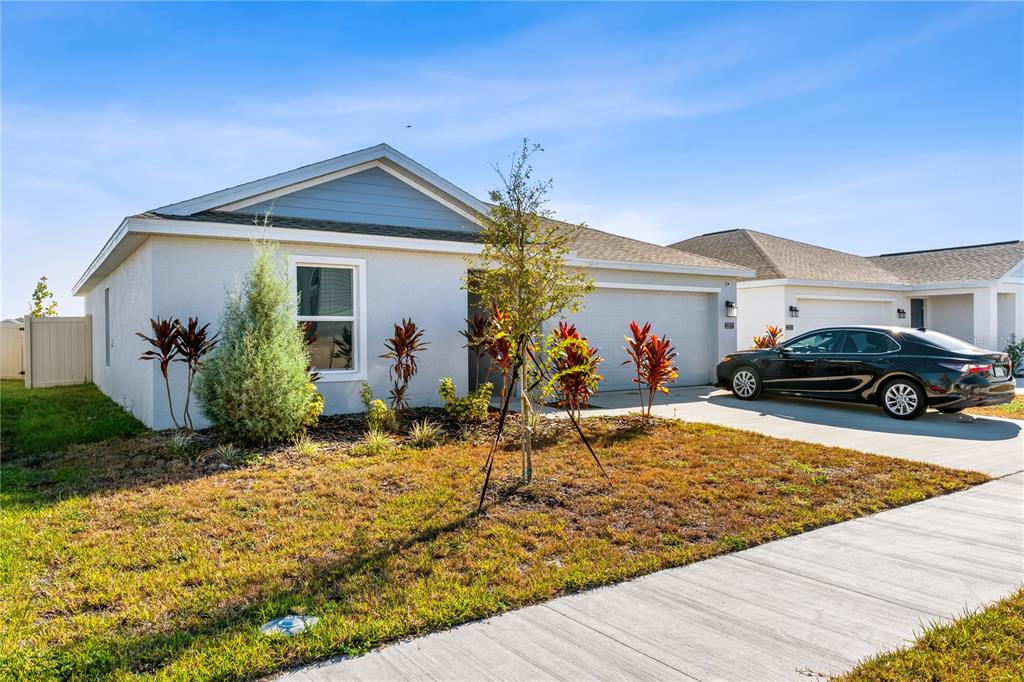 A single-story suburban house with a gray exterior, a two-car garage, and a landscaped yard — 2307 SCARLET AVENUE, WINTER HAVEN, FL