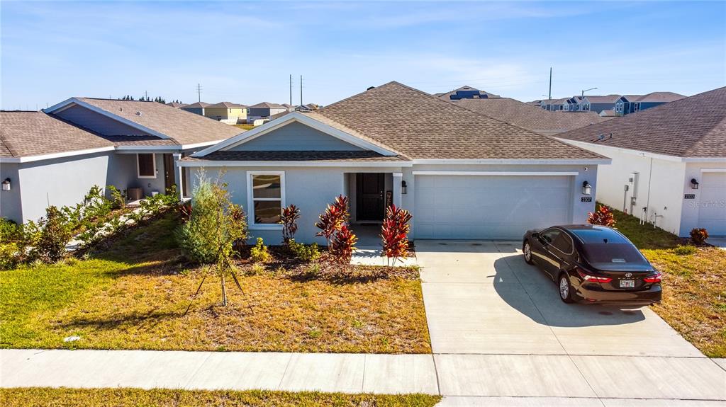 A single-story house with a light blue exterior, a two-car garage, and a driveway — 2307 SCARLET AVENUE, WINTER HAVEN, FL