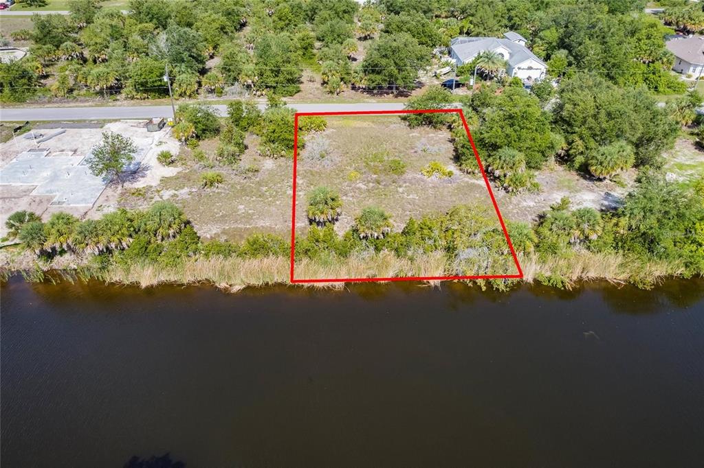 An aerial view shows a vacant, rectangular waterfront lot outlined in red — 9508 PRESIDENT CIRCLE, PORT CHARLOTTE, FL