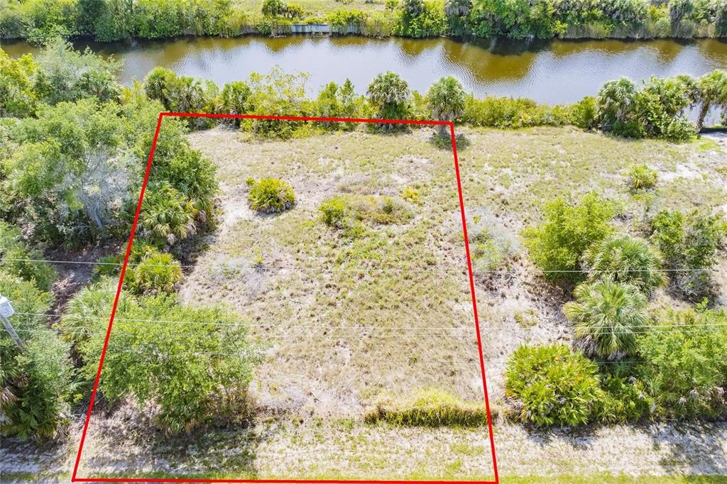 An aerial view of a vacant, rectangular lot bordered by vegetation and a canal — 9508 PRESIDENT CIRCLE, PORT CHARLOTTE, FL