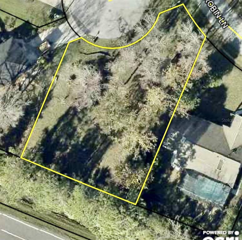 An aerial view shows a vacant, wooded residential lot outlined in yellow on a cul-de-sac — 1 WESTROBIN PLACE, PALM COAST, FL