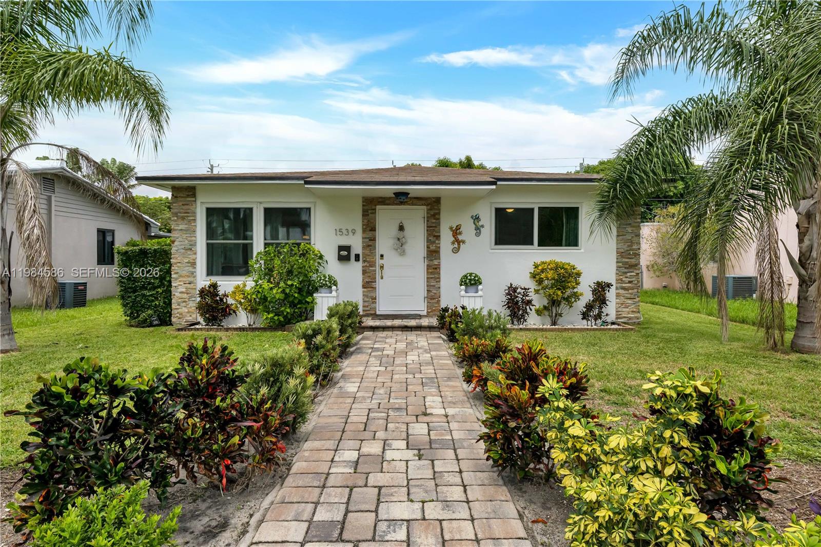 A single-story house with a stone-accented facade and a paved walkway leading to the entrance — 1539 Funston St, Hollywood FL 33020, HOLLYWOOD, FL
