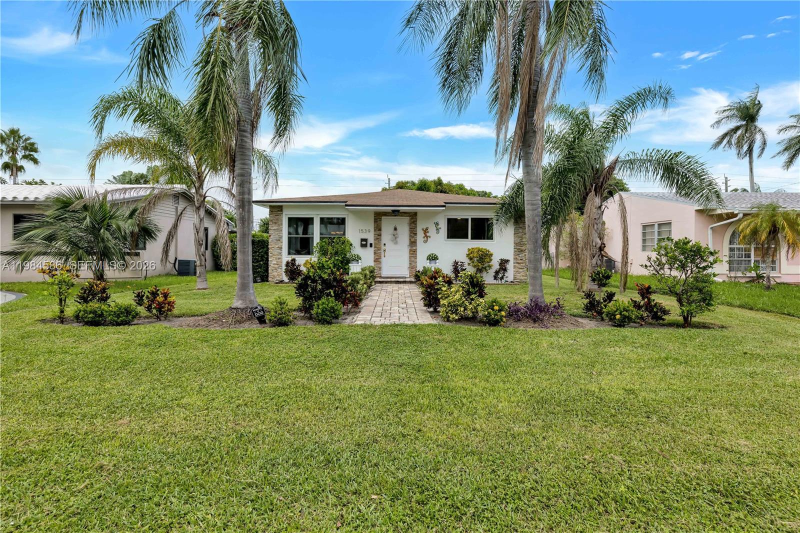 A single-story house with a white facade, stone accents, and a paved walkway — 1539 Funston St, Hollywood FL 33020, HOLLYWOOD, FL