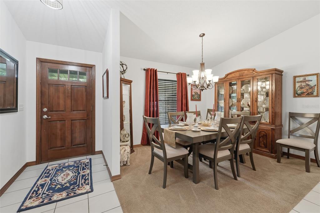 A dining room with a wooden table, chairs, hutch, and an adjacent entryway with tile — 386 LAKE CHARLES ROAD, DELAND, FL