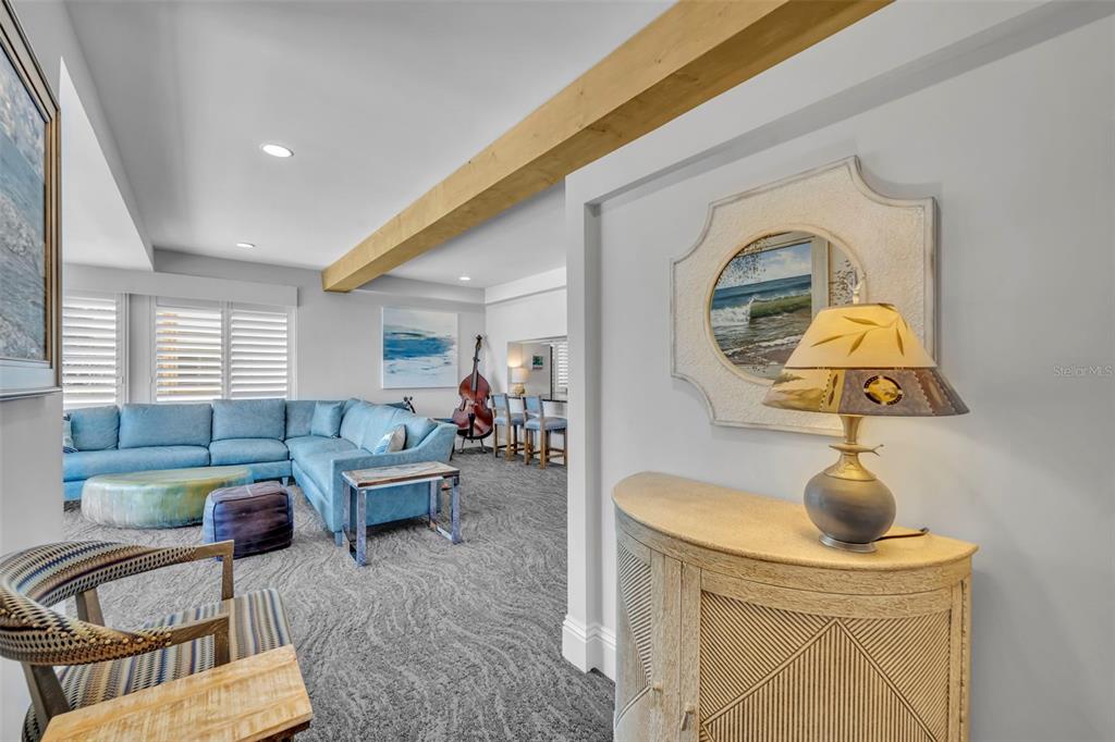 A living room features a blue sectional sofa, a wooden ceiling beam, and a console table — 311 E MORSE BOULEVARD UNIT 1-3, WINTER PARK, FL