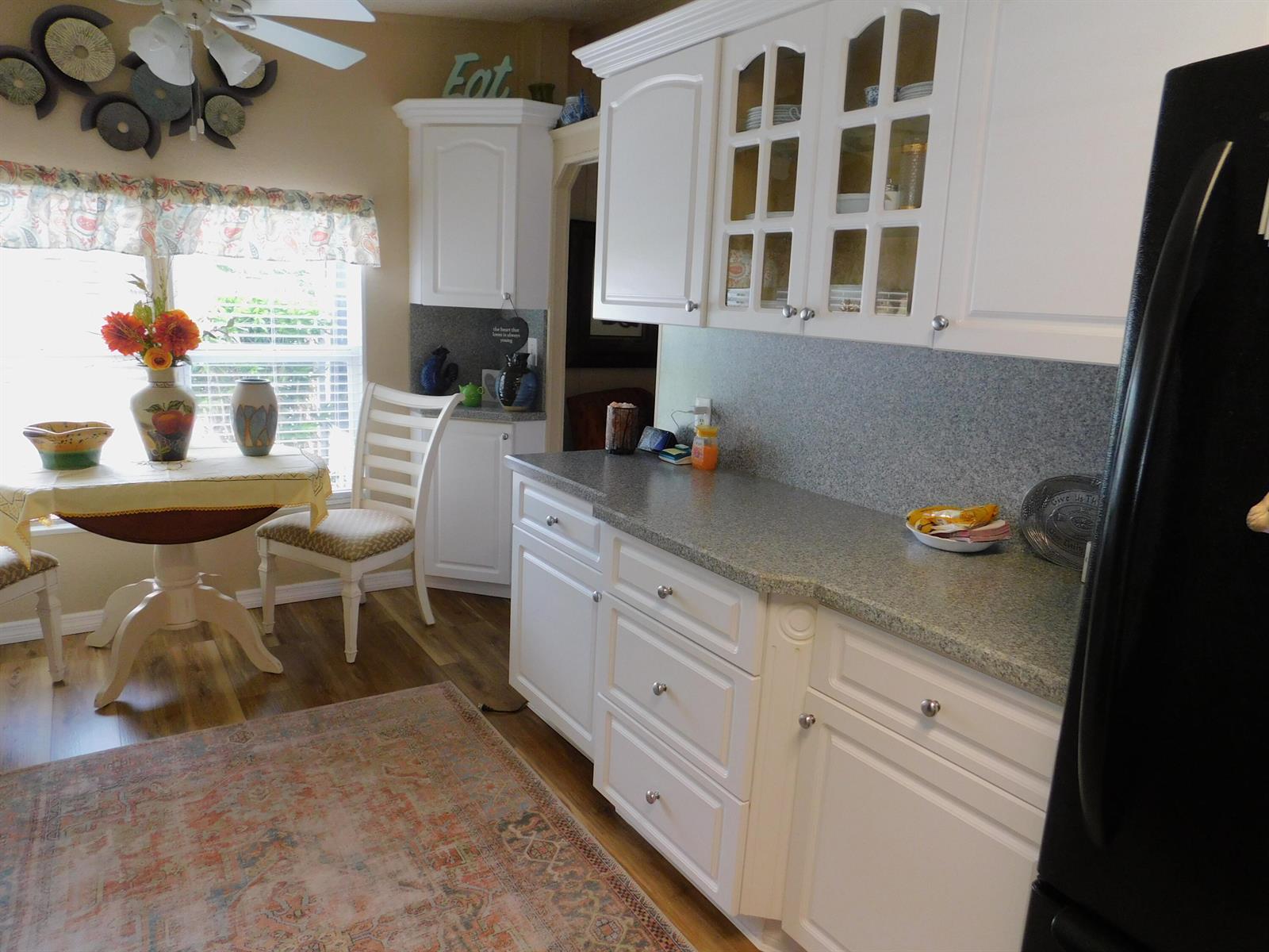 A kitchen features white cabinets, gray countertops, a dining table, and a patterned area rug — 485 Hemingway Terrace # 04, Fort Pierce FL 34982, FORT PIERCE, FL