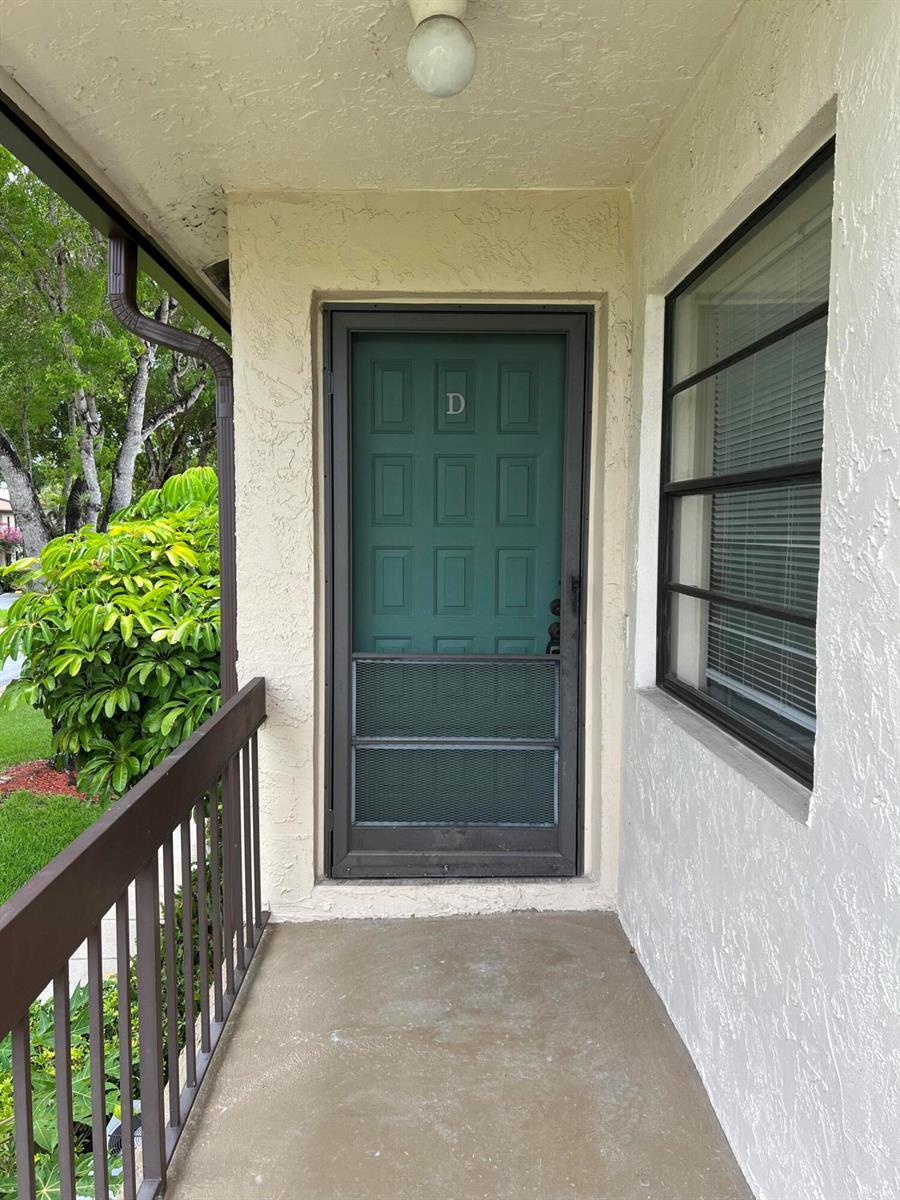 A covered entryway features a green screen door labeled D and a window on the right — 8436 Cypress Lane # 7d, Boca Raton FL 33433, BOCA RATON, FL
