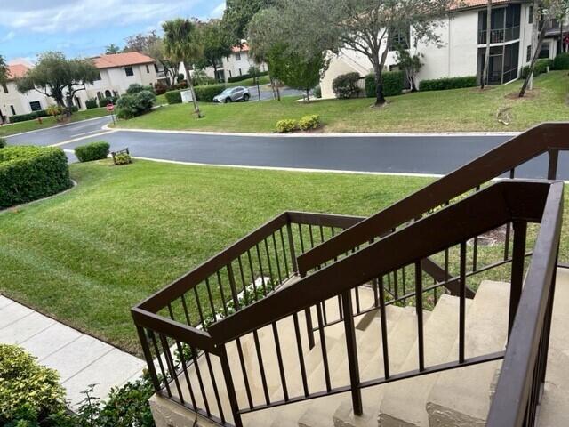 An outdoor view from a staircase looking down at a grassy lawn and a road — 8436 Cypress Lane # 7d, Boca Raton FL 33433, BOCA RATON, FL