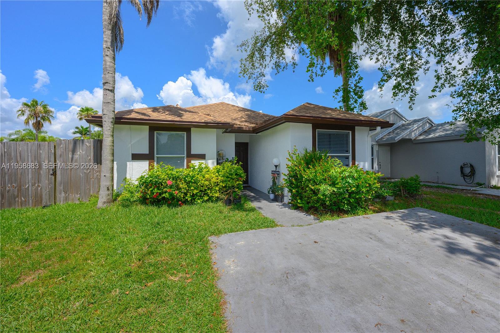 A single-story house with a white stucco exterior, brown trim, and a concrete driveway — 998 SW 8th Pl, Florida City FL 33034, FLORIDA CITY, FL
