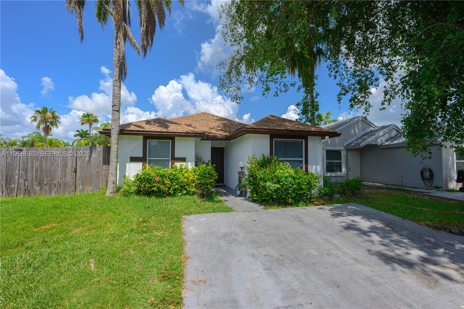A single-story house with a white stucco exterior, brown roof, and a concrete driveway — 998 SW 8th Pl, Florida City FL 33034, FLORIDA CITY, FL