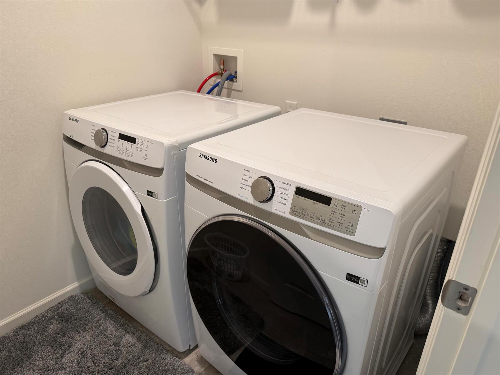 A laundry room featuring a side-by-side Samsung washer and dryer set on a gray rug — 9511 Potomac Drive, Fort Pierce FL 34945, FORT PIERCE, FL