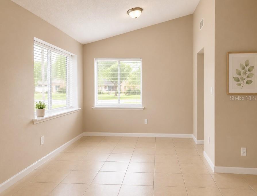 A bright dining area with beige walls, tile flooring, and two windows — 1152 OLD SOUTH DRIVE, LAKELAND, FL