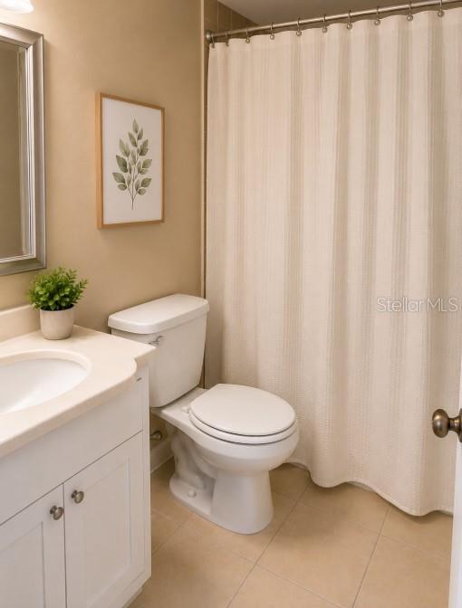 A bathroom features a white vanity, a toilet, and a shower with a beige curtain — 1152 OLD SOUTH DRIVE, LAKELAND, FL