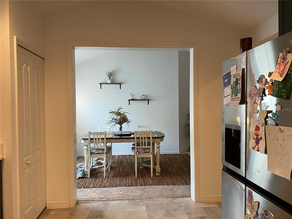 A dining room with a wooden table and chairs is viewed through a doorway — 1880 THOMPSON PRESERVE BOULEVARD, BARTOW, FL