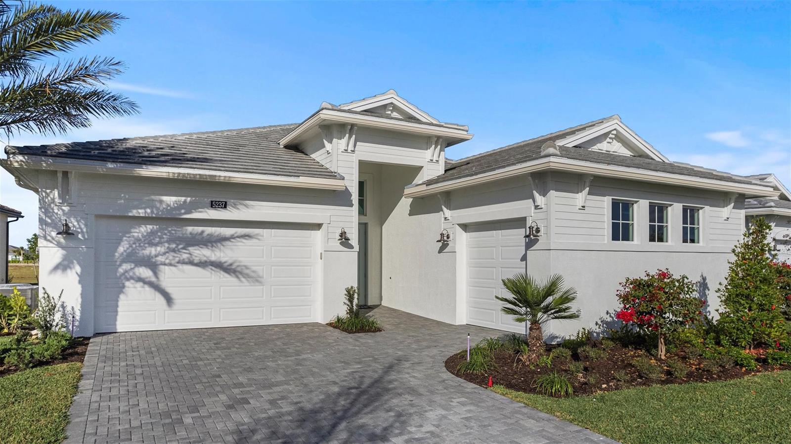 A single-story house with a gray tile roof, white siding, and a paved driveway — 5237 Rivo Alto Circle, Westlake FL 33470, WESTLAKE, FL