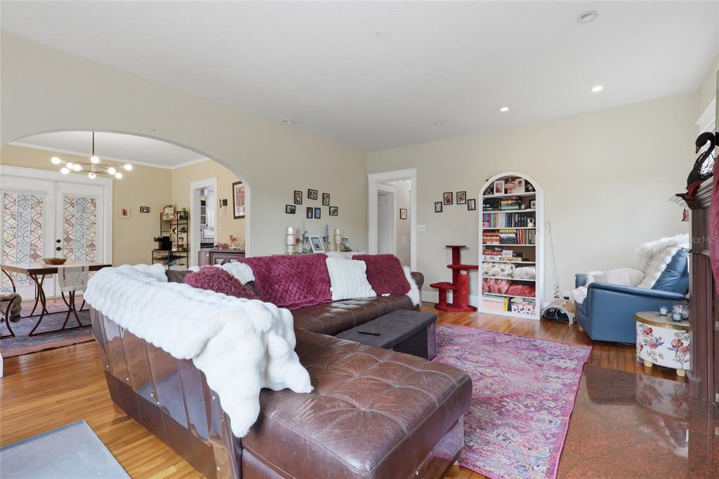 A living room features a brown leather sectional, a pink area rug, and a built-in bookshelf — 8115 N 37TH STREET, TAMPA, FL