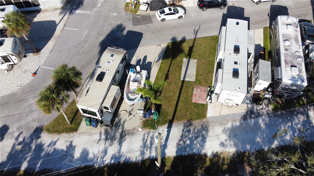 An aerial view shows two recreational vehicles parked on concrete pads with a boat between them — 136 BAHIA DRIVE, PALMETTO, FL