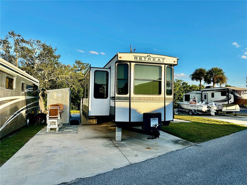A Keystone Retreat destination trailer sits on a concrete pad next to another RV — 136 BAHIA DRIVE, PALMETTO, FL