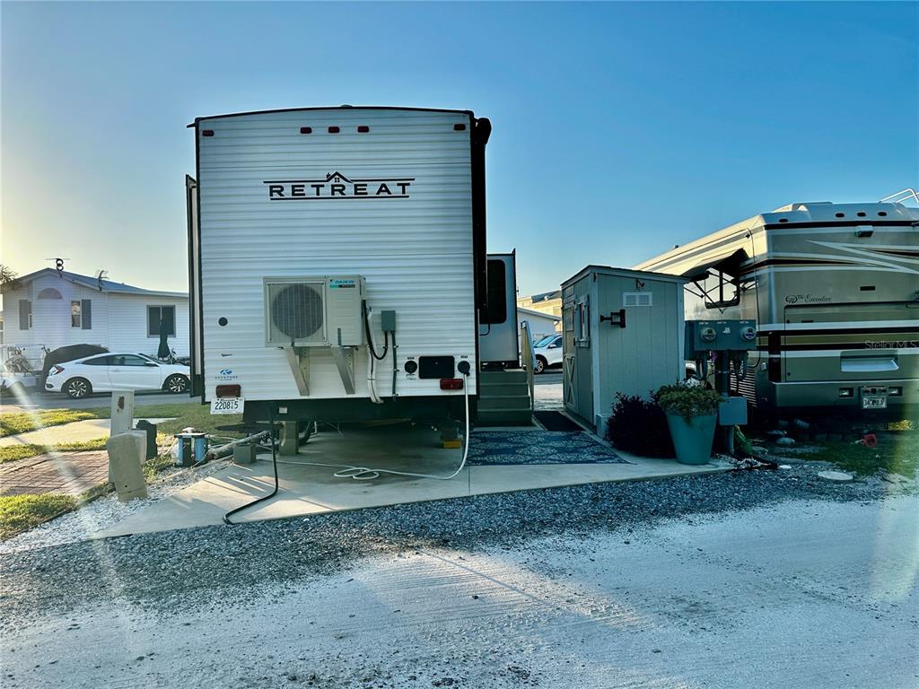 A Retreat destination trailer and a motorhome parked on a gravel lot with a shed — 136 BAHIA DRIVE, PALMETTO, FL
