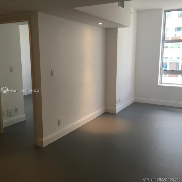 An interior view of a room with white walls, gray flooring, and a large window — 111 E Flagler St # 1003, Miami FL 33131, MIAMI, FL