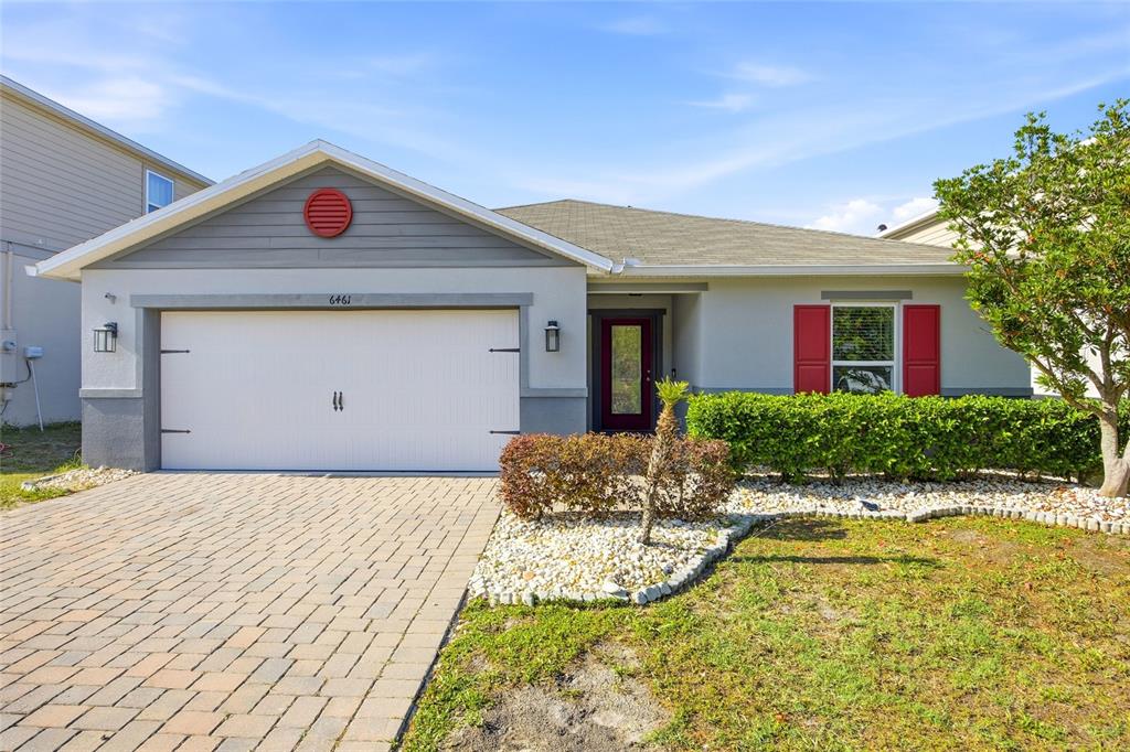 A single-story house with a white garage, gray siding, and red shutters — 6461 DOMENICO COURT, GROVELAND, FL