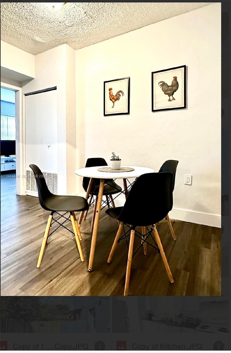 A dining area features a round white table with four black chairs on wood floors — 1821 NW 33rd  St, Miami FL 33142, MIAMI, FL