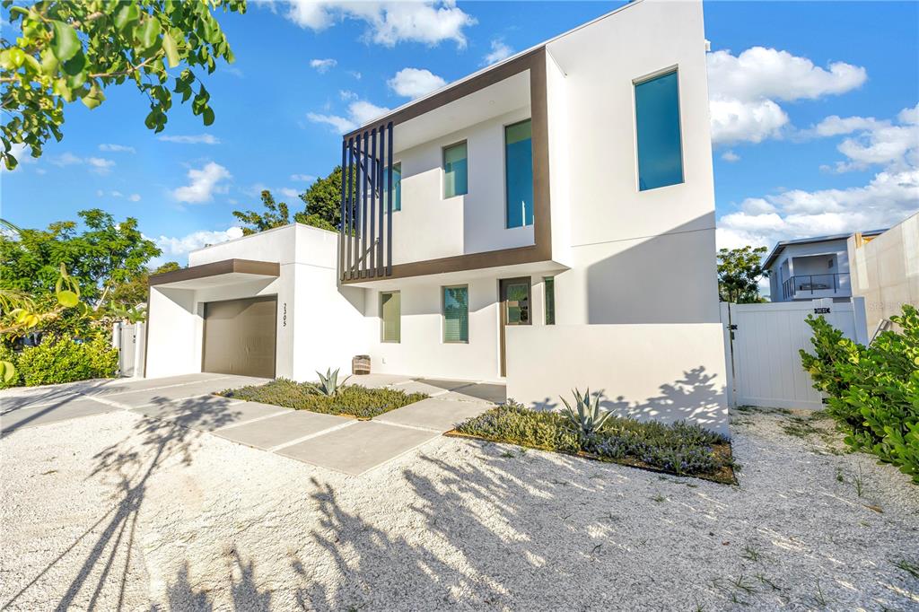 A modern two-story white house features a flat roof, dark trim, and a gravel driveway — 2305 TEMPLE STREET, SARASOTA, FL