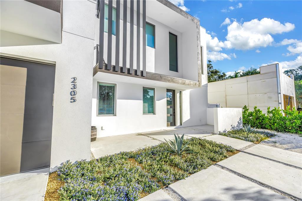 The exterior of a modern two-story white house features vertical slats and a concrete driveway — 2305 TEMPLE STREET, SARASOTA, FL