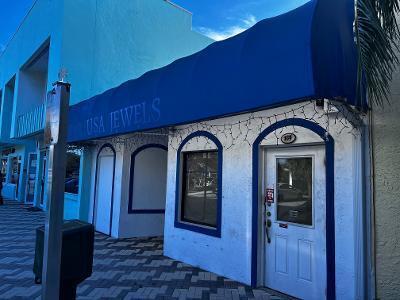 The exterior of a white building with a blue awning and the sign USA JEWELS — 109 SE 15th Terrace, Deerfield Beach FL 33441, DEERFIELD BEACH, FL
