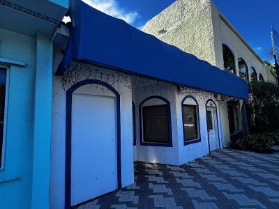 A white building exterior features a large blue awning and arched window frames — 109 SE 15th Terrace, Deerfield Beach FL 33441, DEERFIELD BEACH, FL