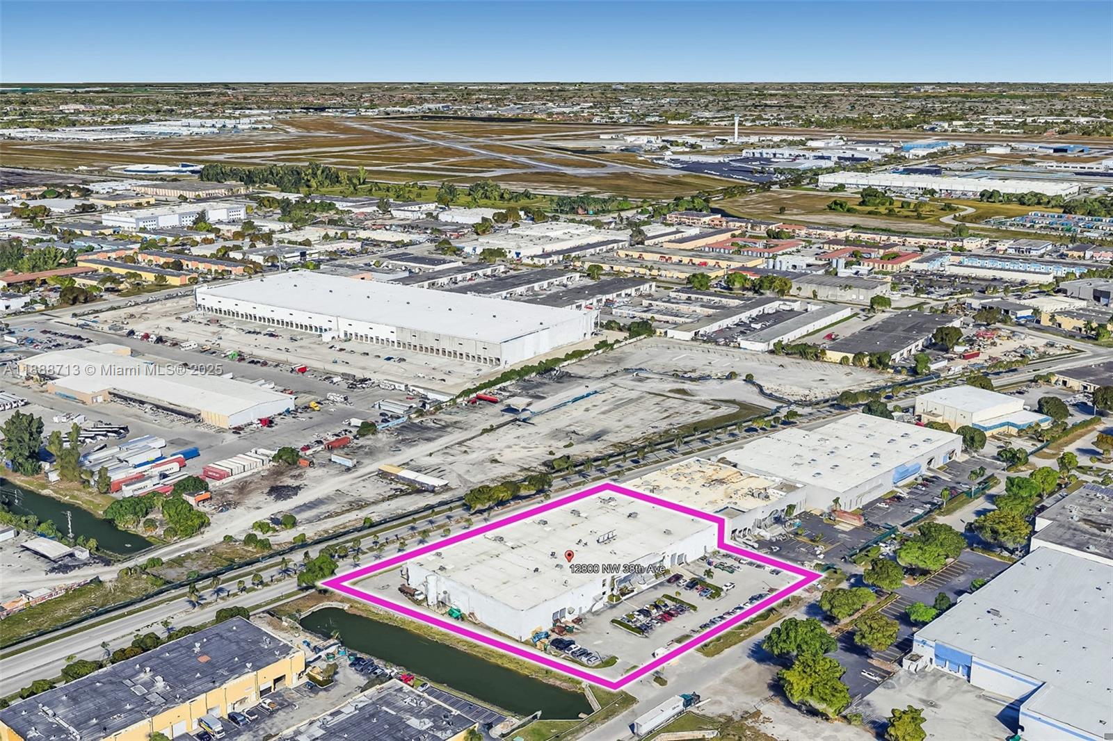 An aerial view shows a rectangular industrial warehouse building outlined in pink — 12800 NW 38th Ave, Opa-Locka FL 33054, OPA-LOCKA, FL