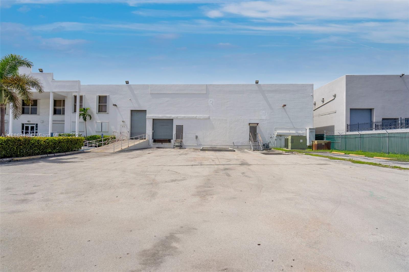 A large, white industrial warehouse building features a loading dock and a paved parking lot — 12800 NW 38th Ave, Opa-Locka FL 33054, OPA-LOCKA, FL