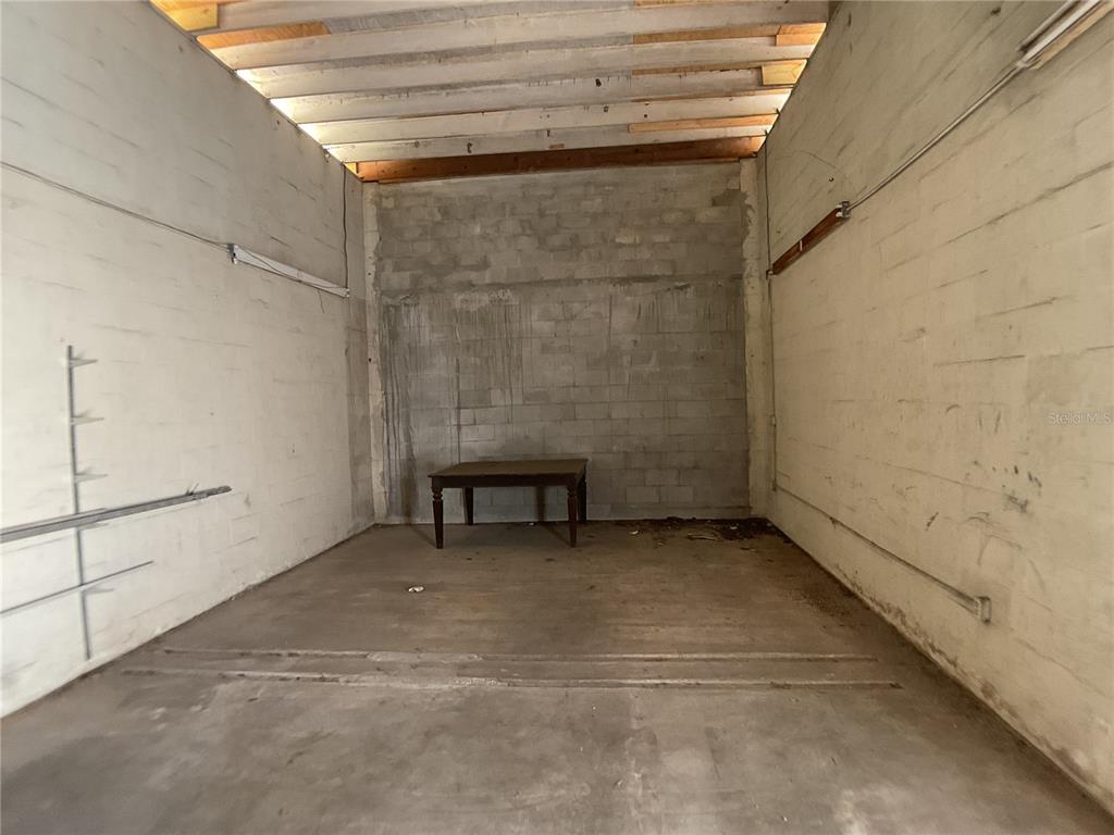 An empty garage with concrete block walls, a concrete floor, and exposed ceiling joists — 4460 SW HIGHWAY 17, ARCADIA, FL