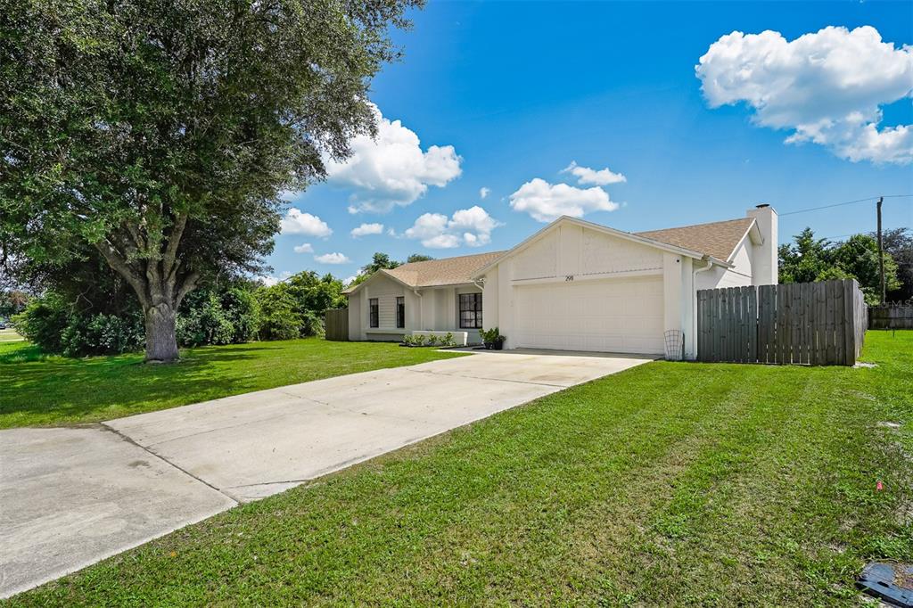 A single-story house with a white exterior, a two-car garage, and a large front lawn — 2911 GRAYTON STREET, DELTONA, FL