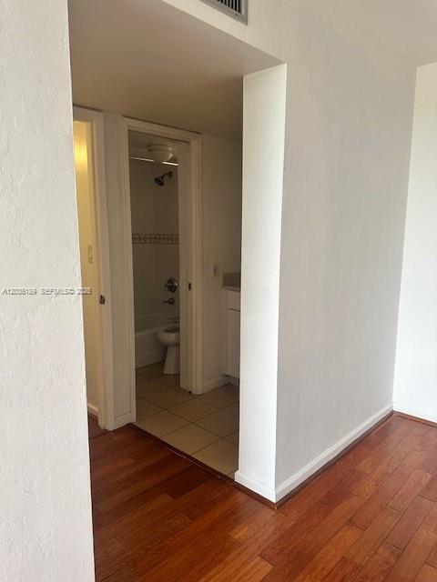 A view from a room with hardwood floors looking into a small bathroom — 870 NW 87th Ave # 302, Miami FL 33172, MIAMI, FL
