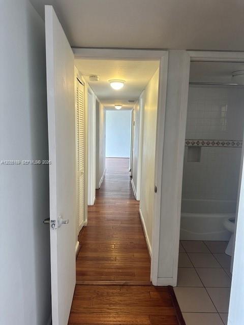 A hallway with wood-look flooring leads to a doorway, with a bathroom visible on the right — 870 NW 87th Ave # 302, Miami FL 33172, MIAMI, FL