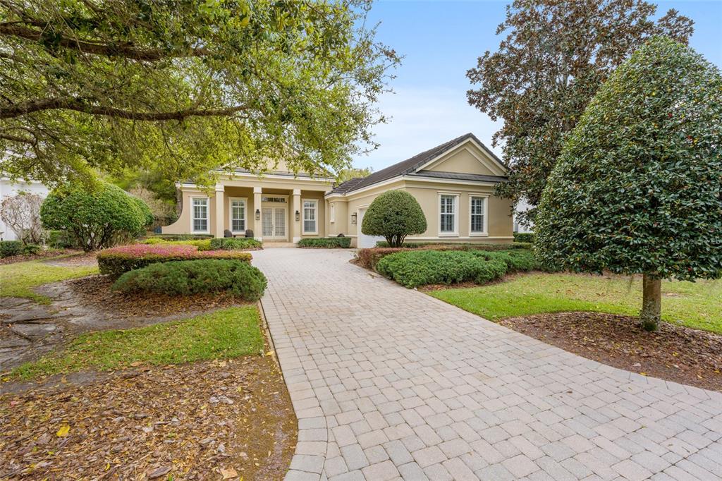 A paved driveway leads to the entrance of a single-story house with beige stucco walls — 2765 NW 80TH AVENUE, OCALA, FL