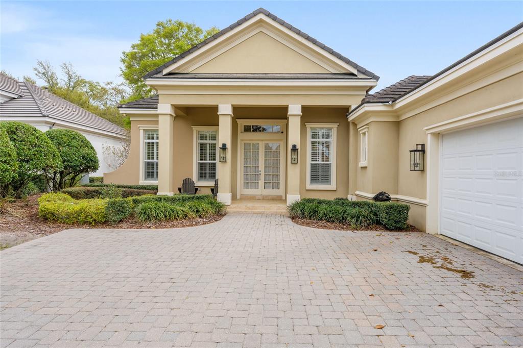A beige house with a paved driveway, a covered entryway, and a white garage door — 2765 NW 80TH AVENUE, OCALA, FL