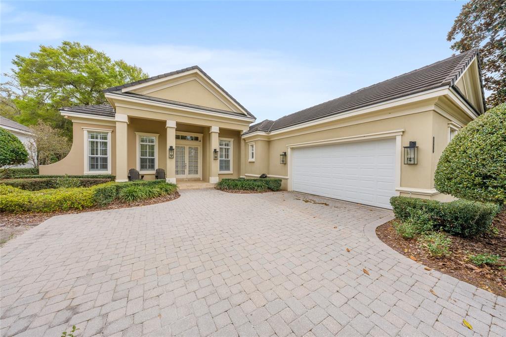A beige house with a paved driveway, a two-car garage, and a columned front entrance — 2765 NW 80TH AVENUE, OCALA, FL