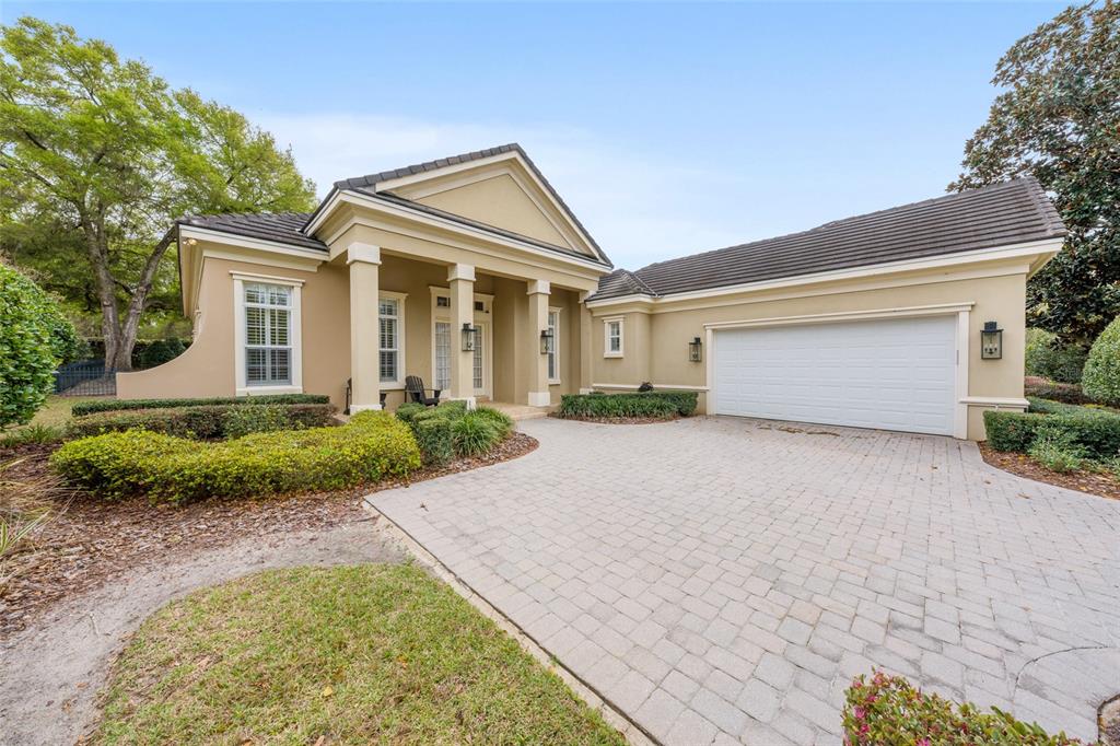 A beige single-story house with a paved driveway, a two-car garage, and a columned porch — 2765 NW 80TH AVENUE, OCALA, FL