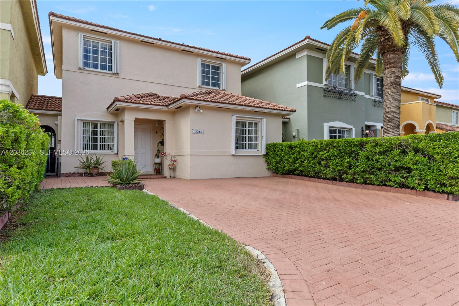 A two-story beige house with a tiled roof and a brick-paved driveway — 13364 SW 143rd St, Miami FL 33186, MIAMI, FL