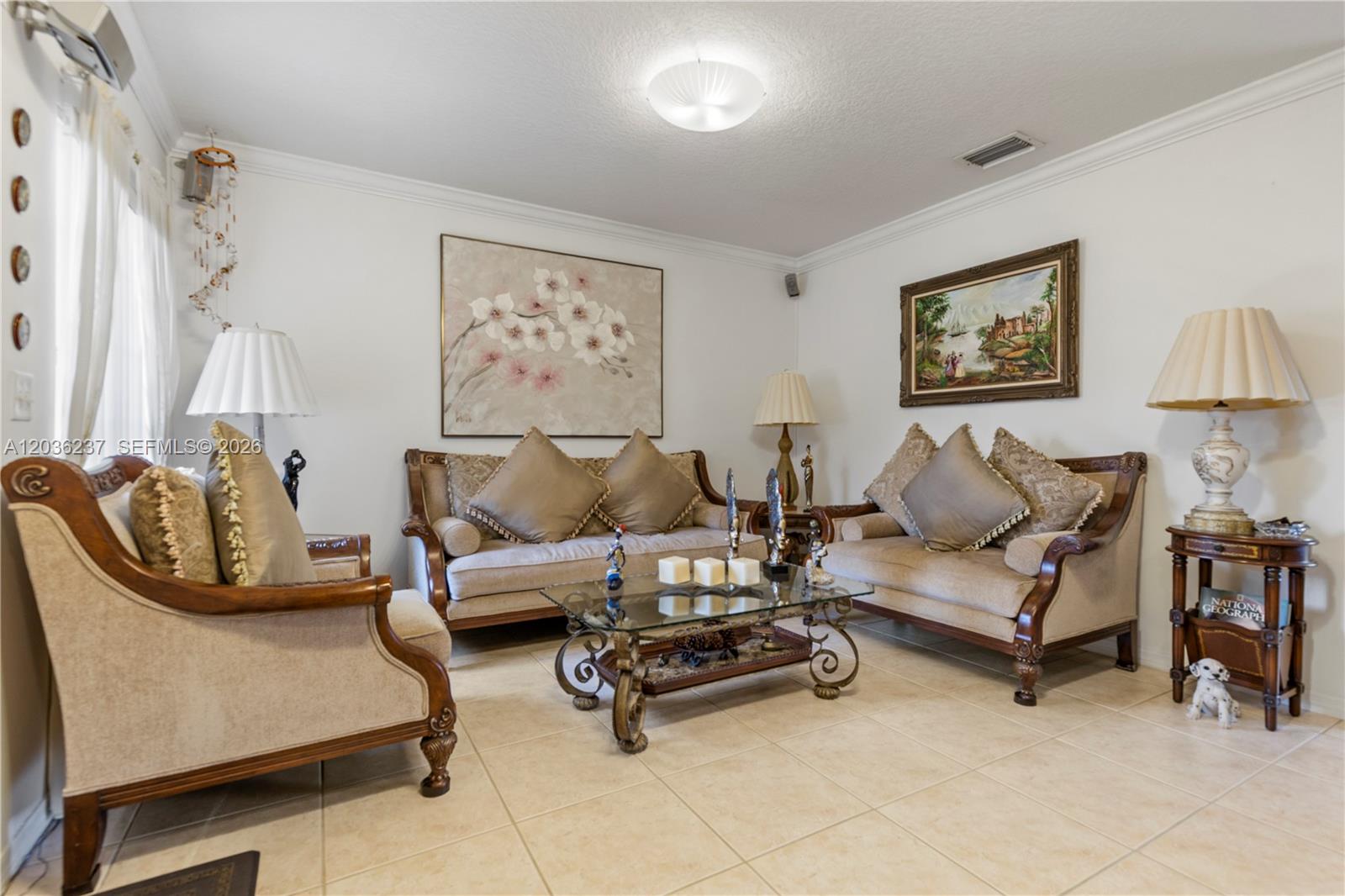 A living room features beige tile floors, two sofas, an armchair, and decorative wall art — 13364 SW 143rd St, Miami FL 33186, MIAMI, FL