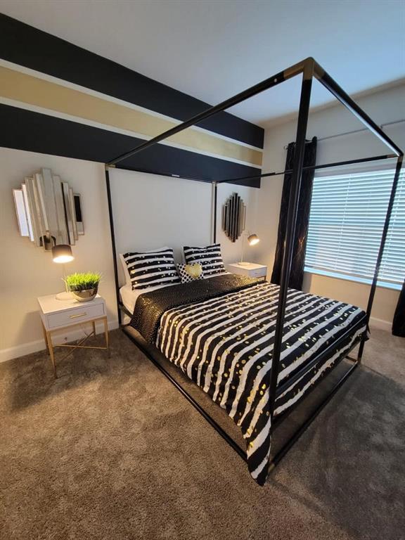 A bedroom features a black canopy bed, striped bedding, and horizontal black and gold wall stripes — 1184 CHALLENGE DRIVE, DAVENPORT, FL