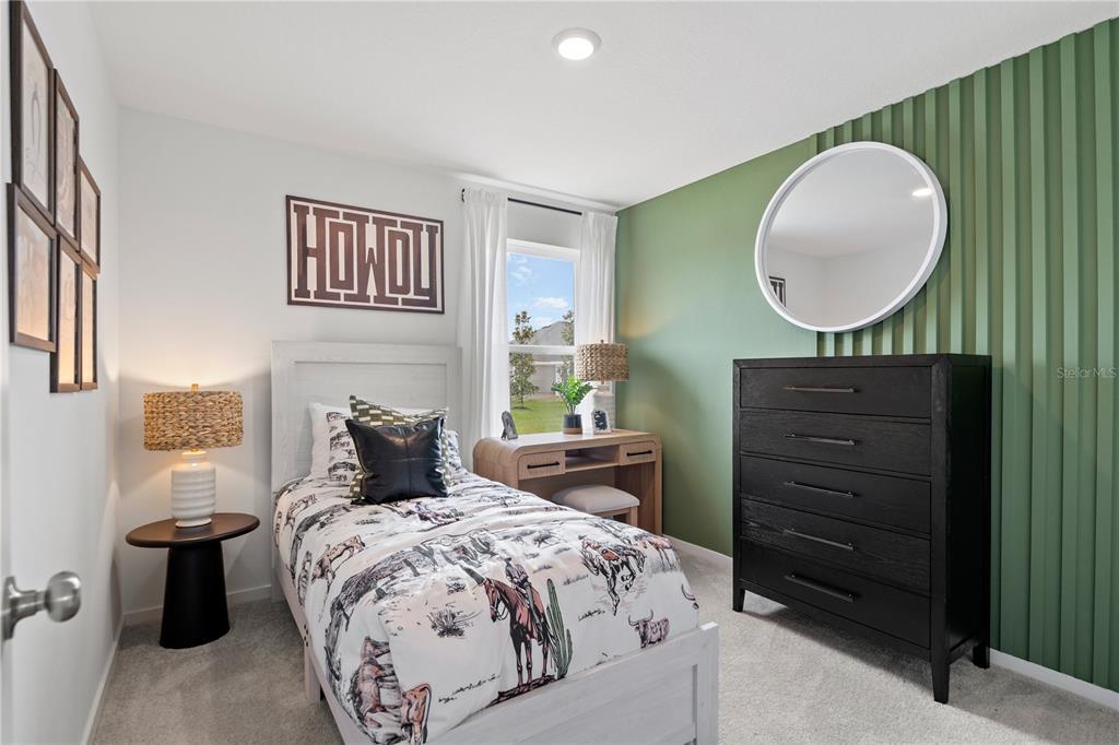 A bedroom features a twin bed, a black dresser, and a green accent wall — 2255 JENNIO DRIVE, HAINES CITY, FL