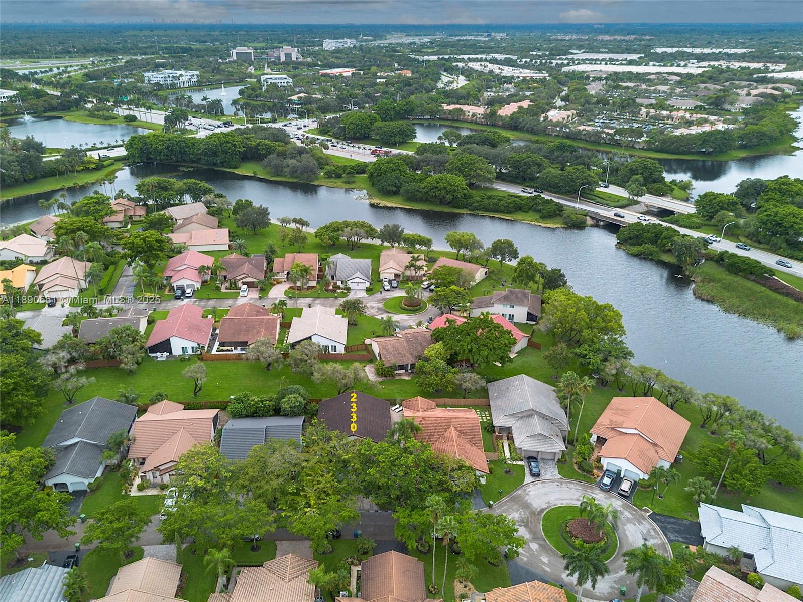 An aerial view shows a residential neighborhood with houses, a winding river, and roads — 2330 Dover, Weston FL 33326, WESTON, FL