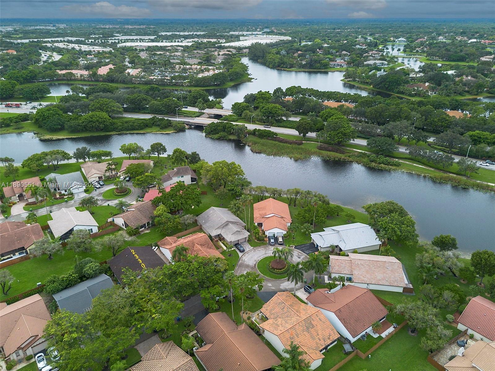 An aerial view shows a suburban neighborhood with houses, a cul-de-sac, and a winding lake — 2330 Dover, Weston FL 33326, WESTON, FL